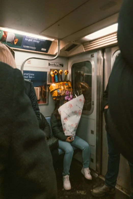 people waiting on a subway car while holding umbrellas