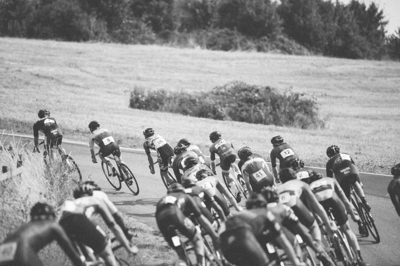 a group of men riding bikes down a curvy street