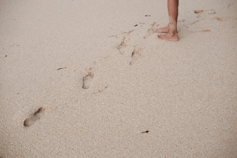 the foot prints of a person standing on a beach