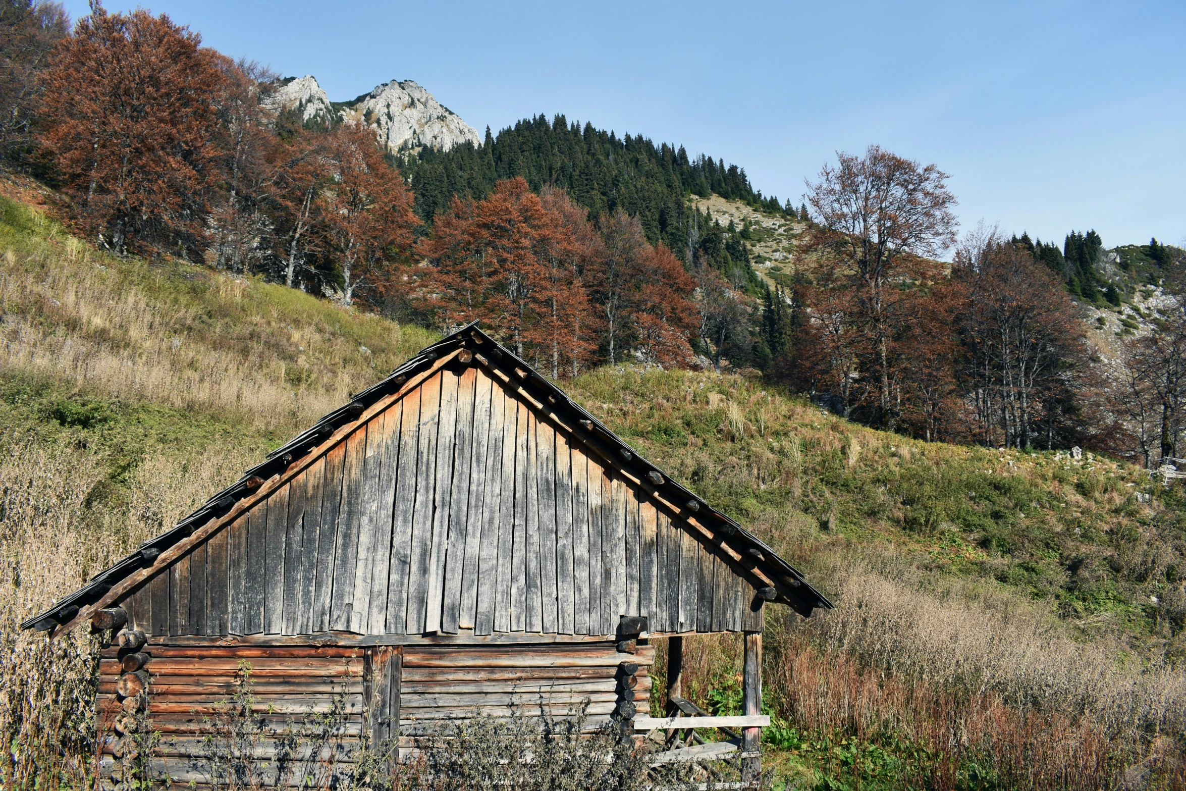 an old log cabin is out in the field