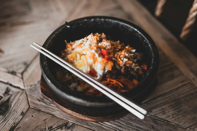 a bowl with noodles, onions, and meats in it