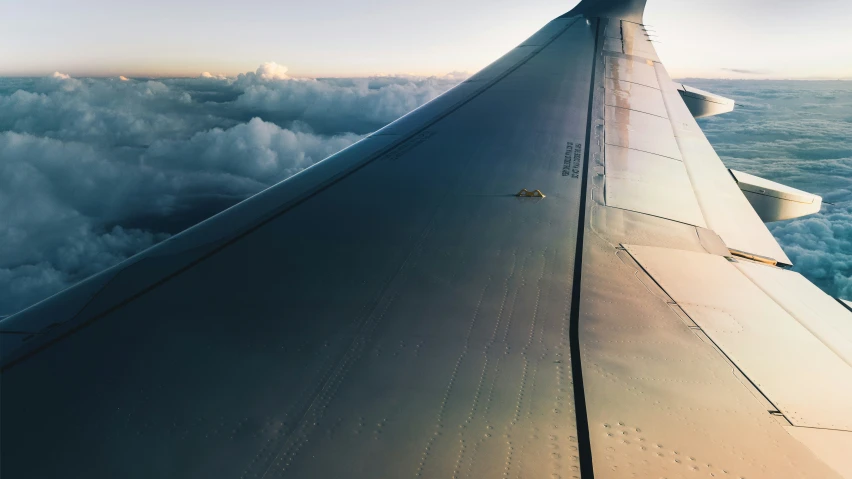 the view from an airplane window shows low clouds