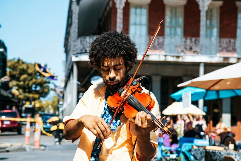 a young man playing the violin in the street