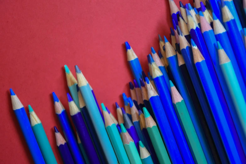 several colors of pencils lined up in a pile