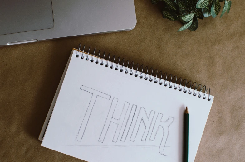 notebook and a pen on the table that is surrounded by items from another type