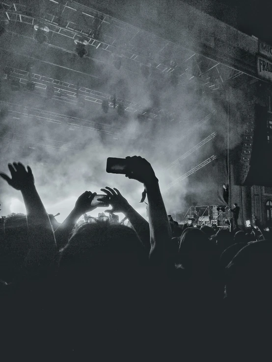 crowd raising their hands in the air at concert