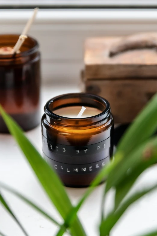 two glass jars sitting next to each other with candle holders in front of it