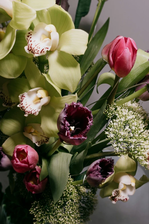 a green vase with some pink and white flowers