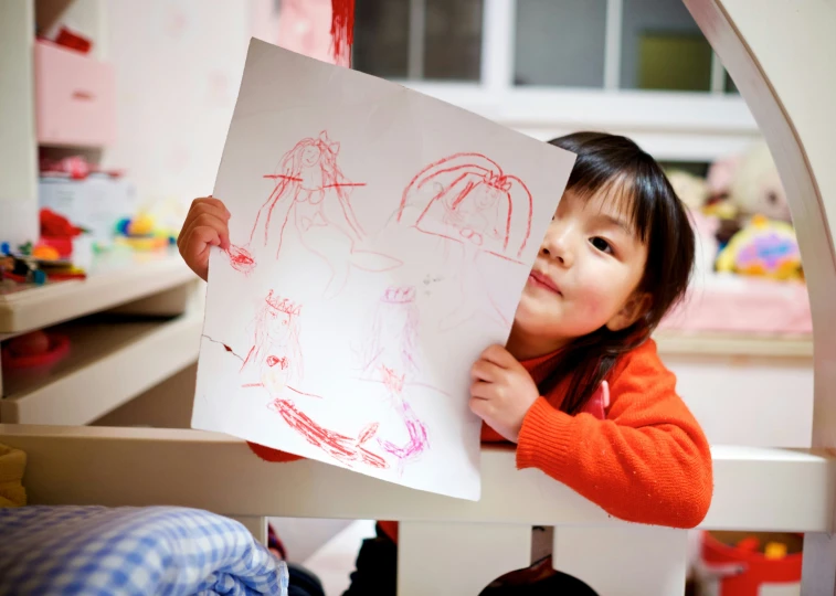 a little girl is holding a drawing board in her hand