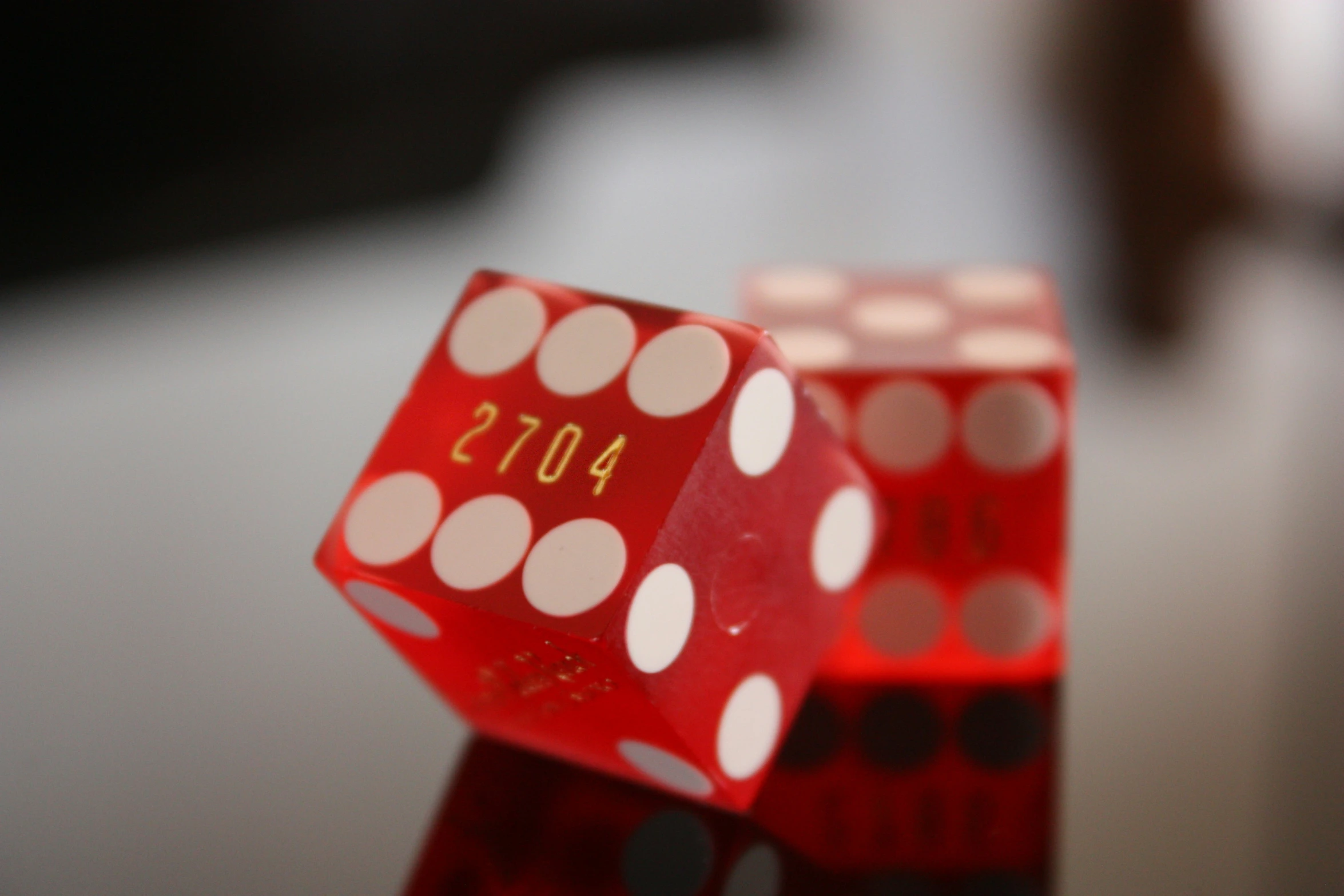 a red dice with white dots sits on a table