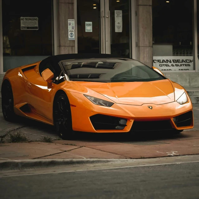 an orange car is parked along the side of the road