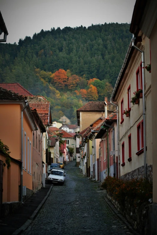 an empty street with parked cars and mountains