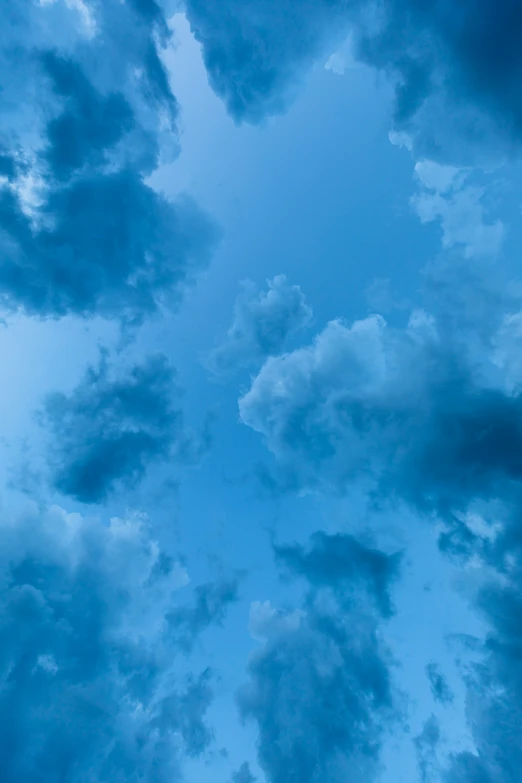 a beautiful blue sky with some clouds and birds flying in it