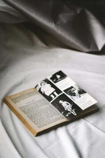 a book on a bed covered in white sheets