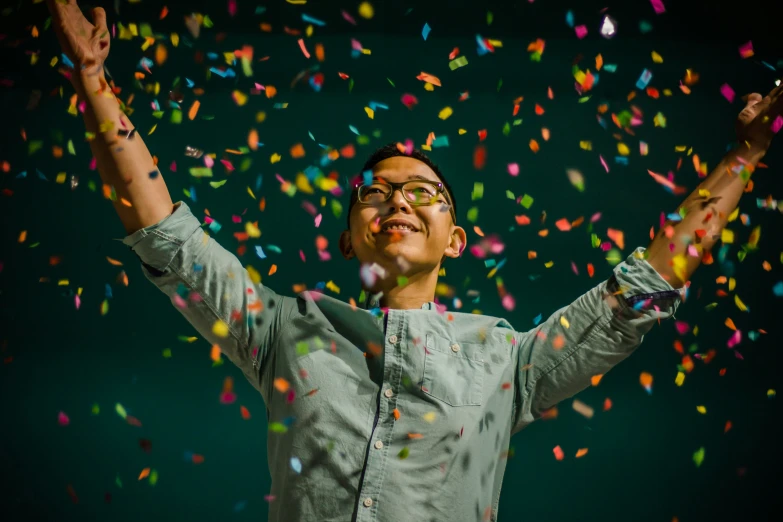 a person standing under a bunch of colorful confetti