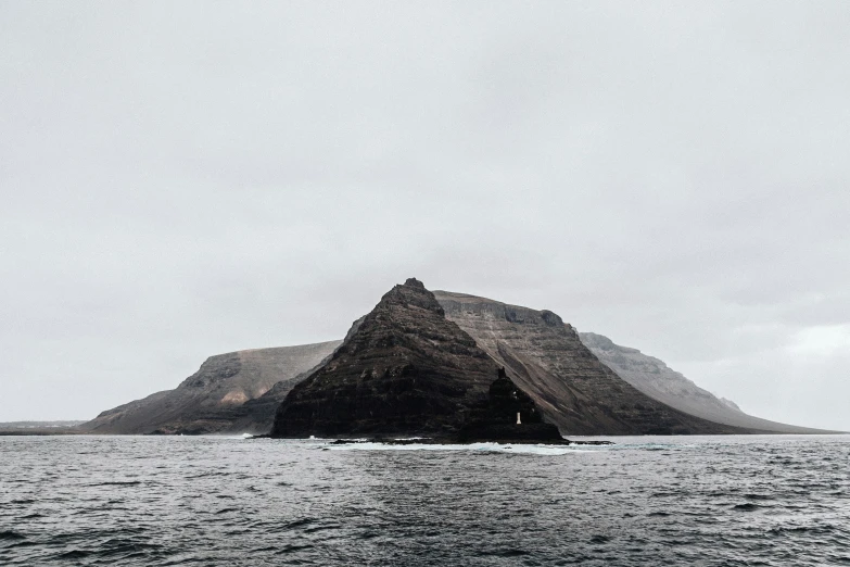 an island in the ocean with a boat in the water