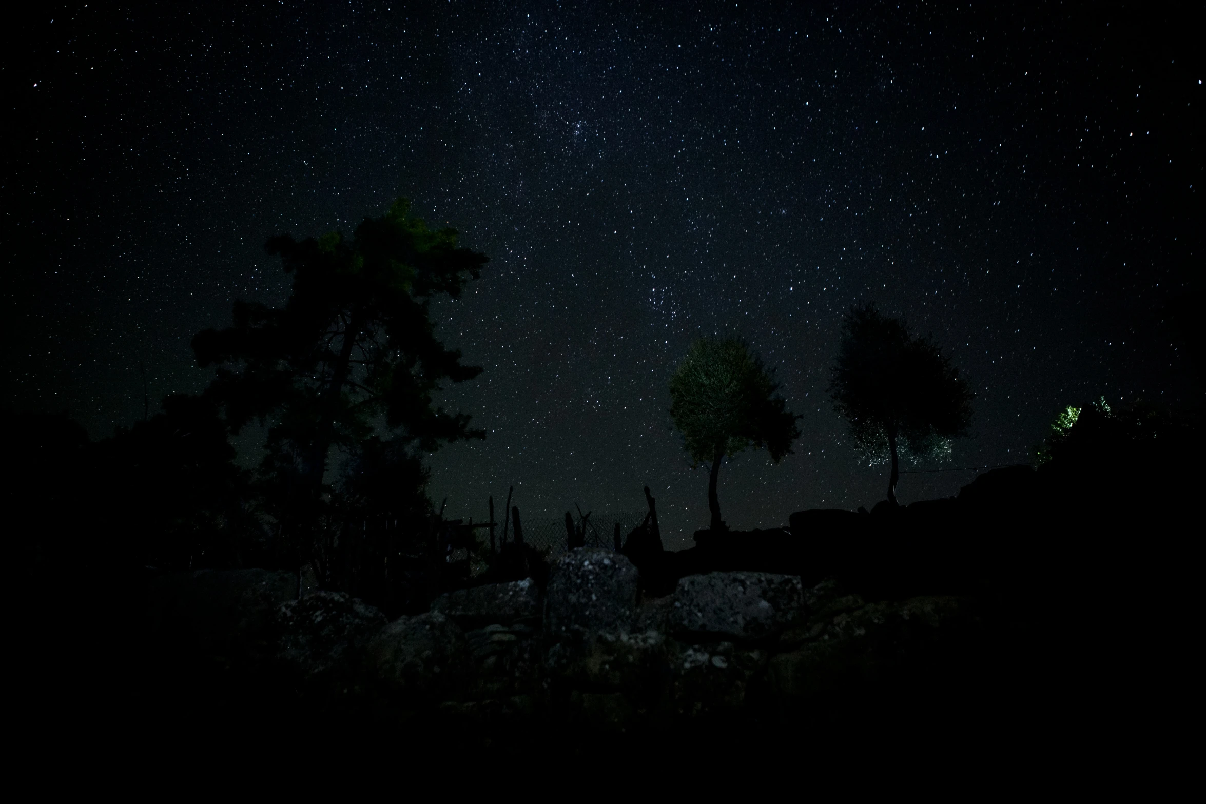 the stars shine brightly over a dark landscape