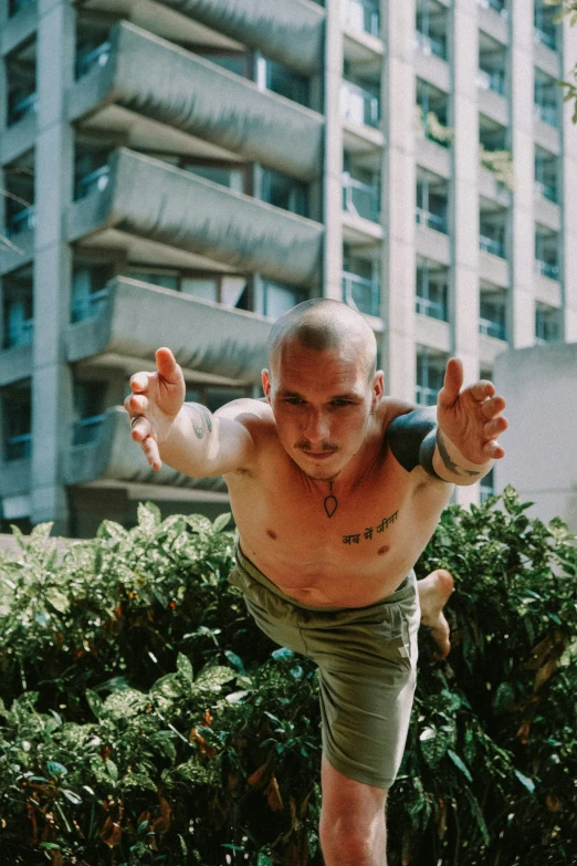 a man wearing shorts and a shirt doing a hand stand