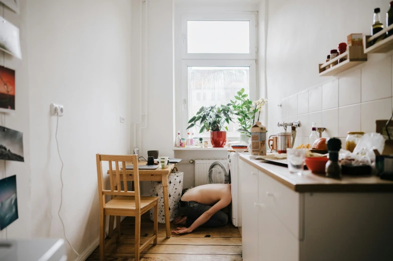 the person is standing in a kitchen and bending over