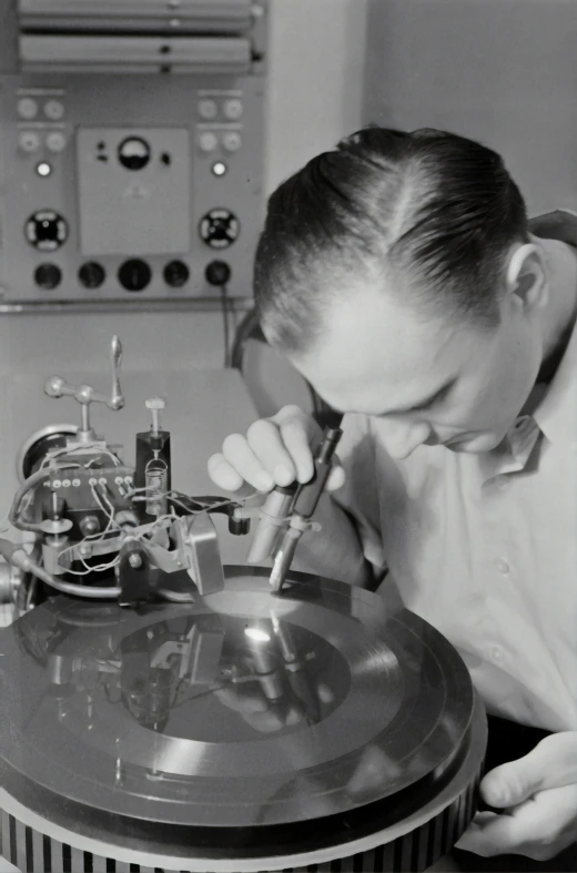 a man looking at an old record player with many other items on it