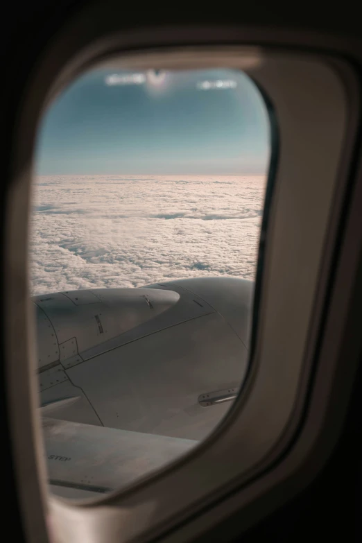 a window looking down into the clouds from inside an airplane