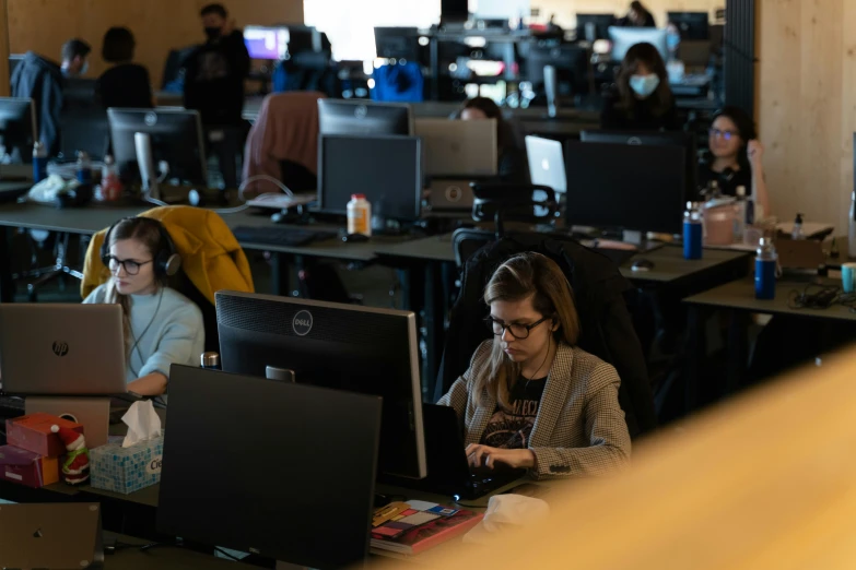 a group of people working on computer screens