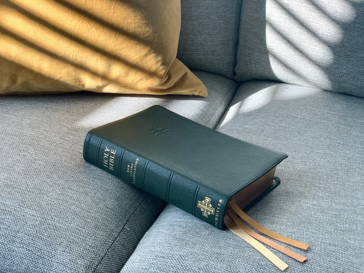 a book sitting on the arm of a couch