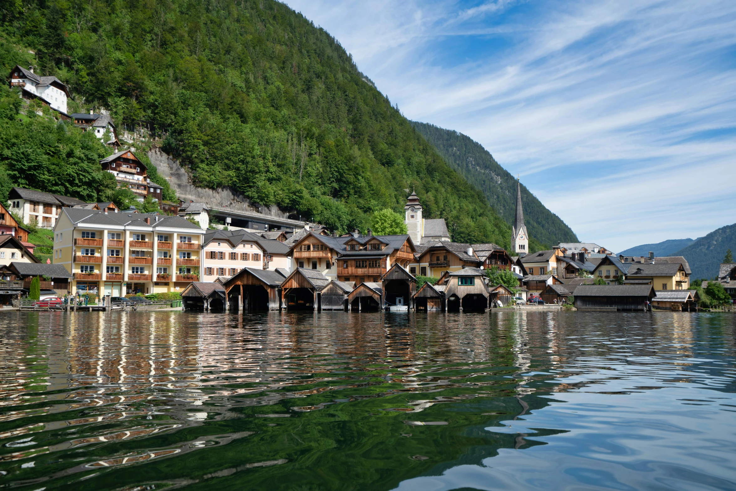 a group of buildings on a mountain side with water reflecting them