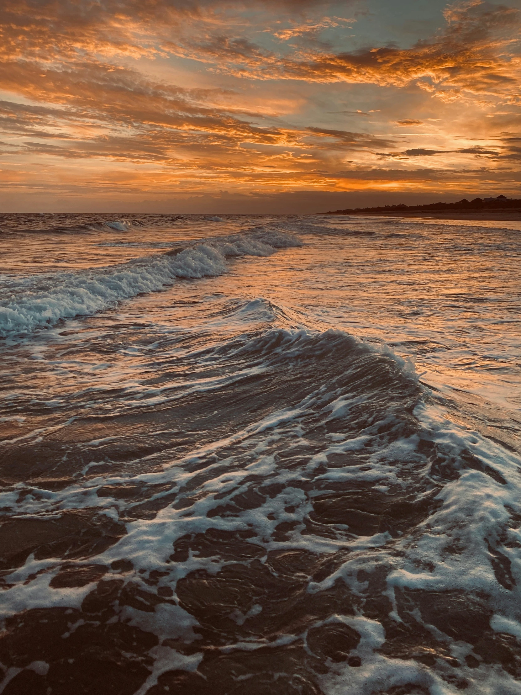 the sun is setting over the ocean with foamy waves