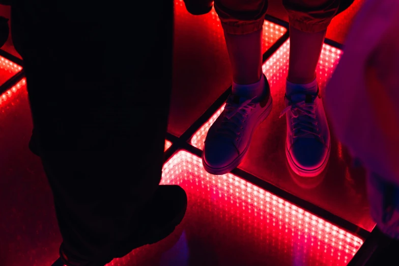 person's legs standing on floor with lit light