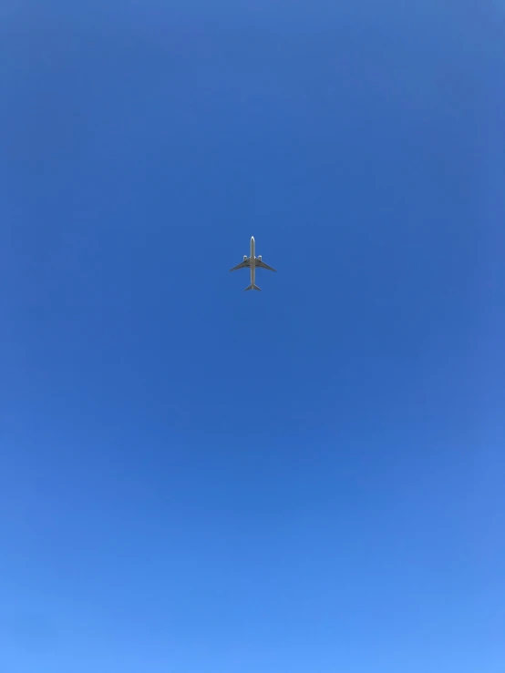 an airplane is flying high in the blue sky