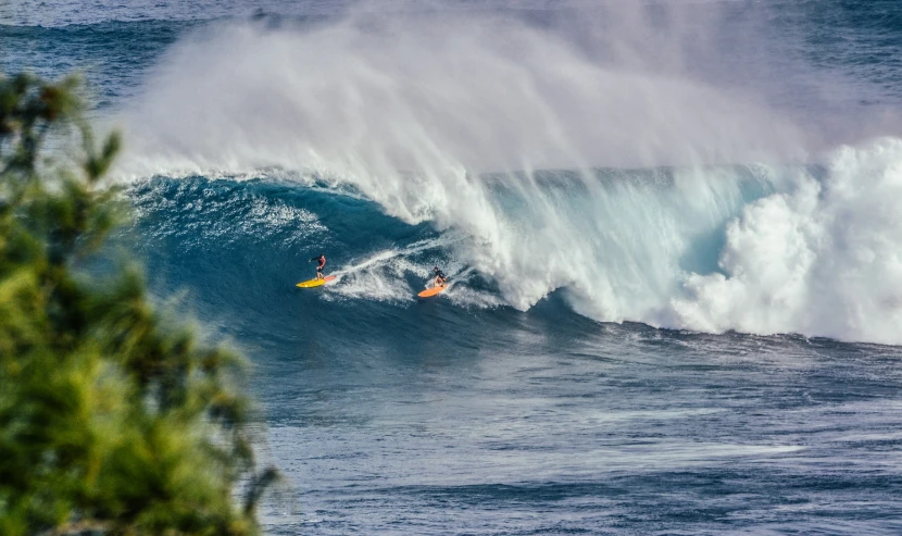 a man riding a wave on top of a yellow surfboard