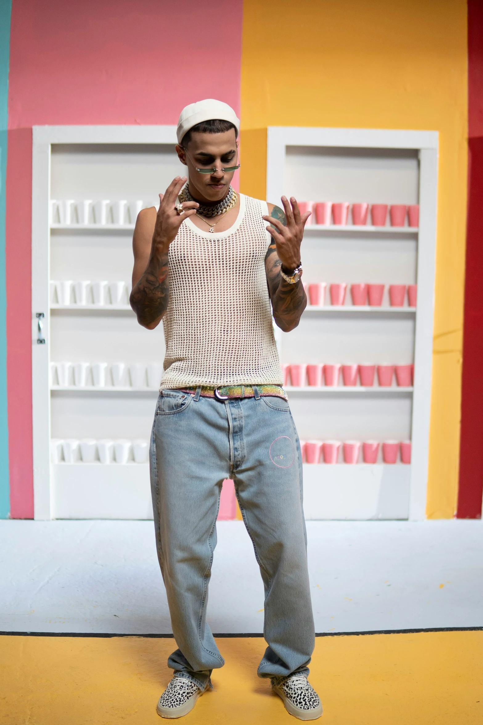 a man that is standing up against a colorful wall