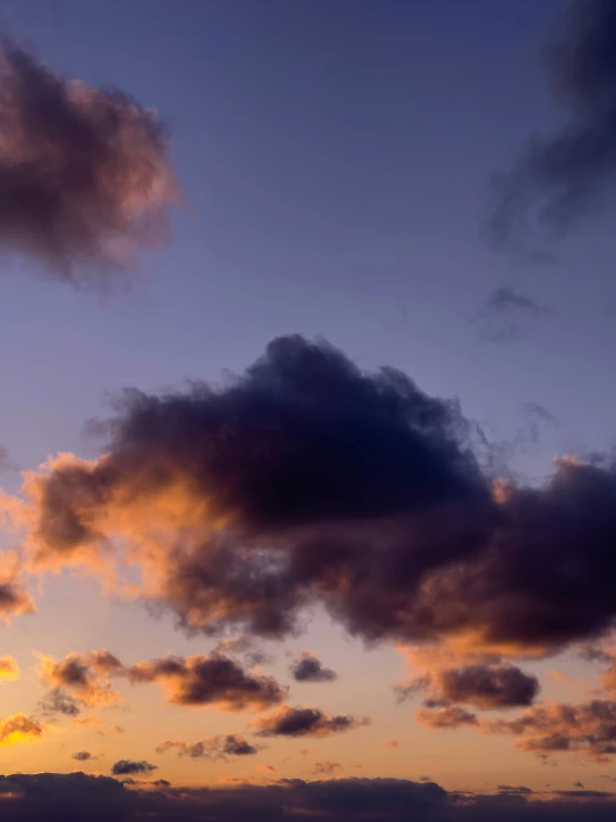 an airplane flying in the sky during sunset