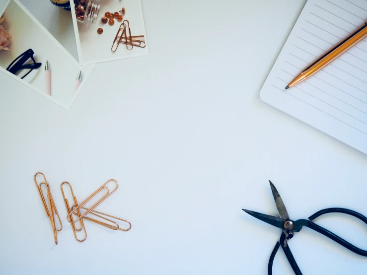 a white surface with several office supplies and scissors