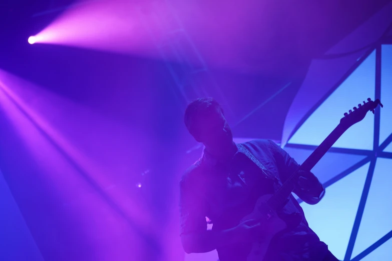 a man that is standing up with a guitar