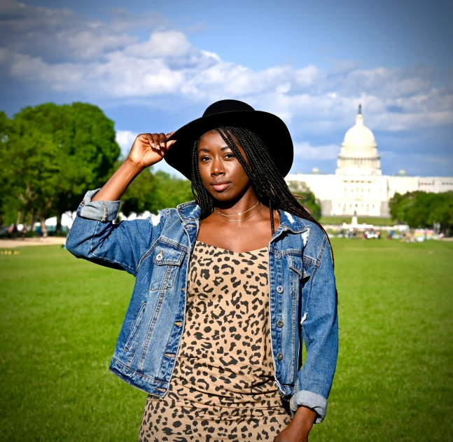 a young woman is posing in a grassy field