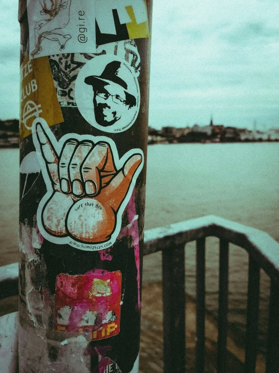 a sticker on the side of a pole has pictures of two fingers