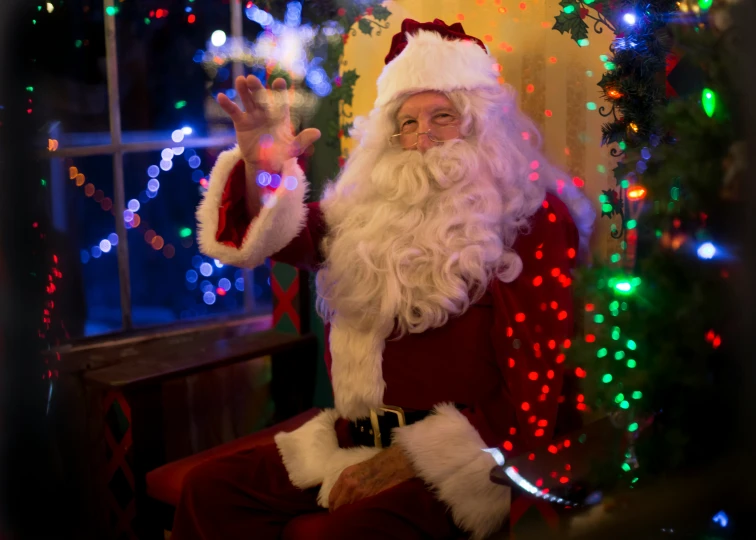 a smiling santa with lights on and hands up