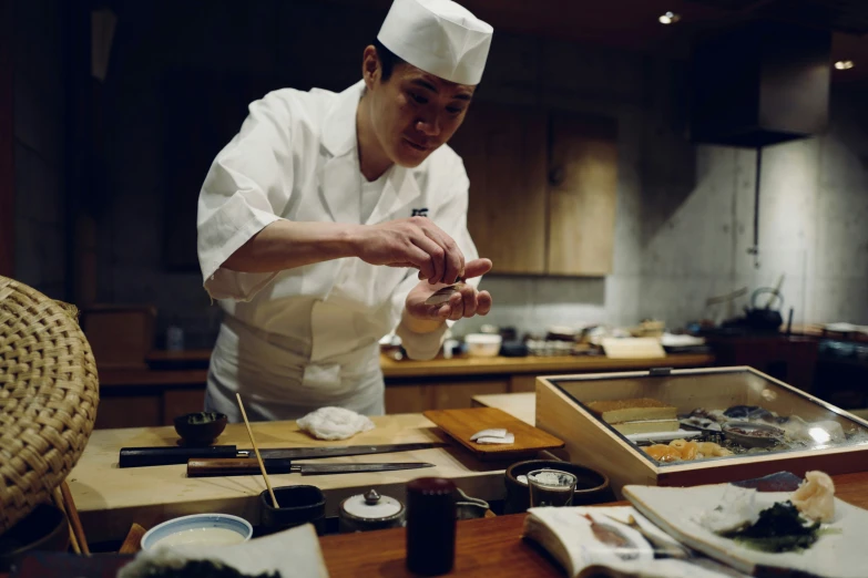 a chef puts a sauce on top of his food