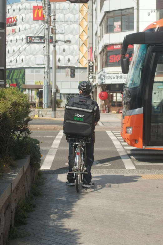 a person on a bike with a large back pack on the street