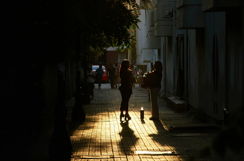 two people walking down a street at night