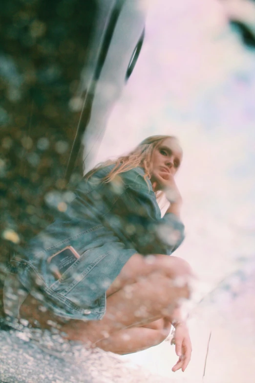 a young woman in denim jacket sitting on the ground