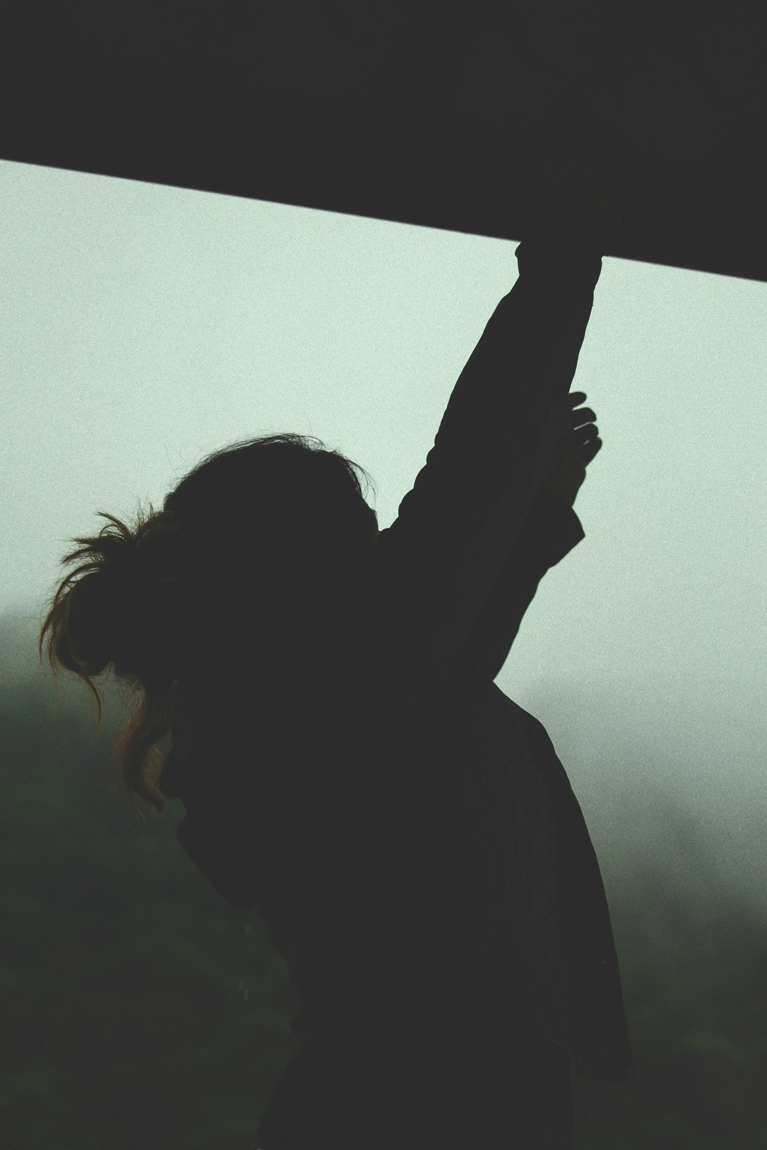 a person with a black shirt holds up an umbrella