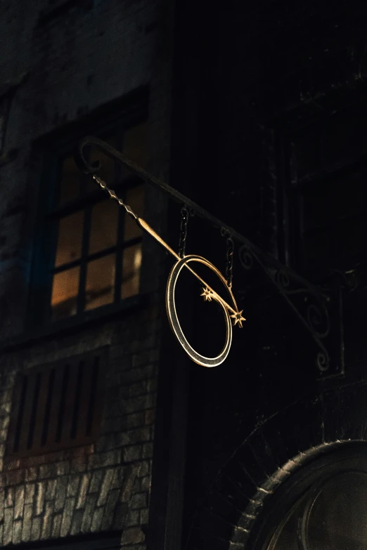 a dark building has a gold object hanging off the side