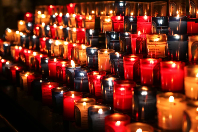 many small red candles are lit near each other