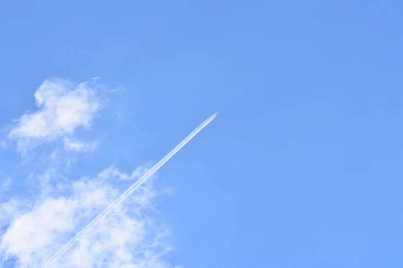 the plane is flying high through the clear sky