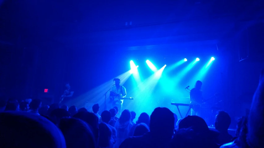 an audience watches as their band plays on stage