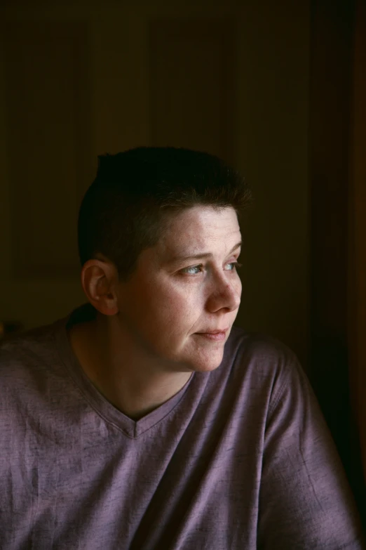 a man with the dark colors of his hair is looking out a window