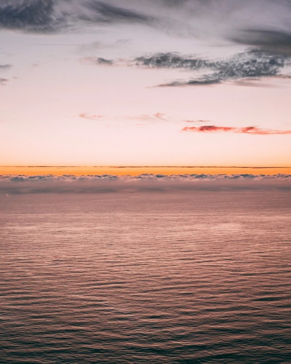 a lone boat is out on the ocean at sunset